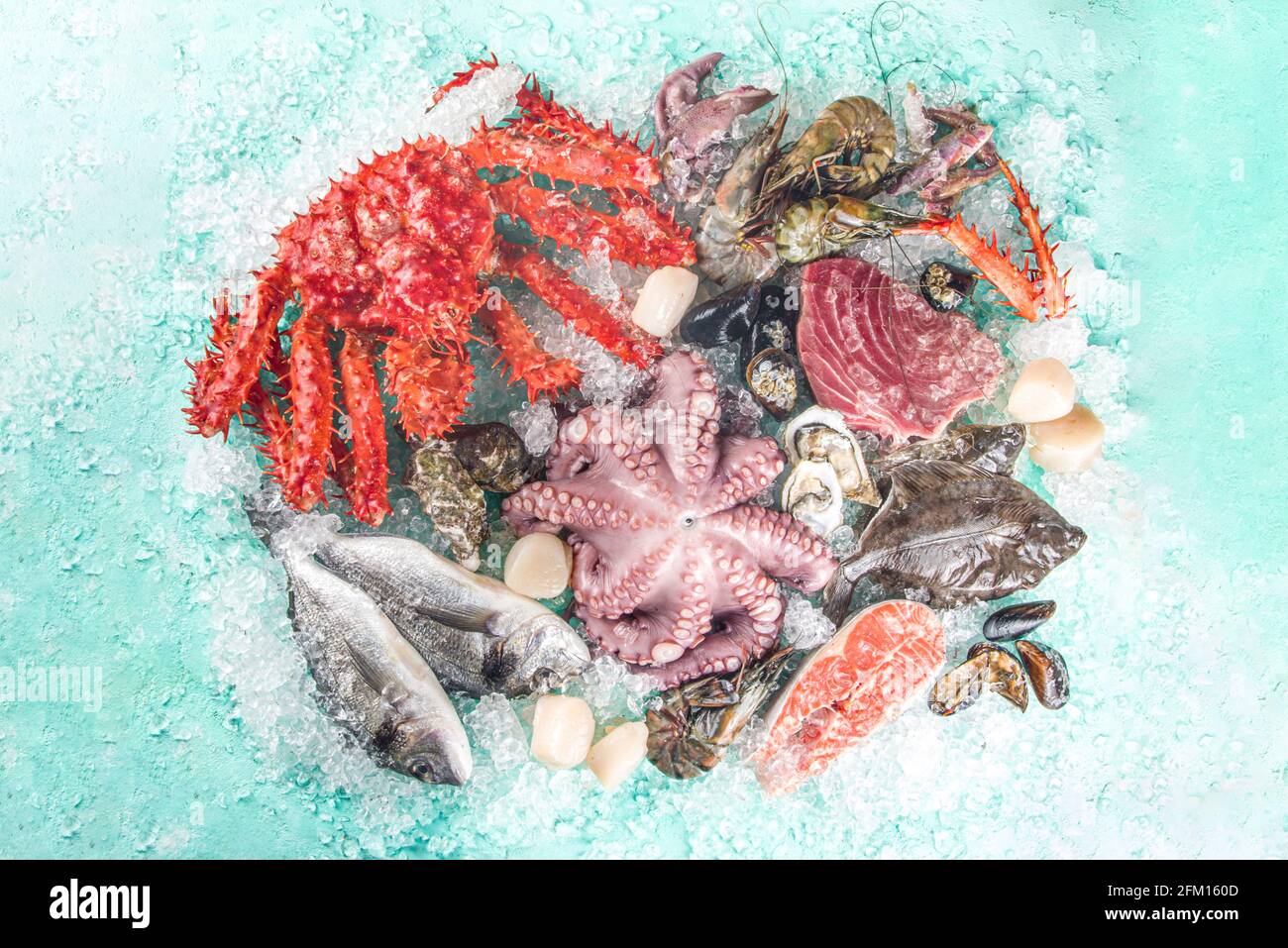 Ensemble de divers fruits de mer frais crus - pieuvre, crabe, calmar, crevettes, huître, moules, saumon thon dorada poisson avec épices d'herbes citron, bleu clair Banque D'Images