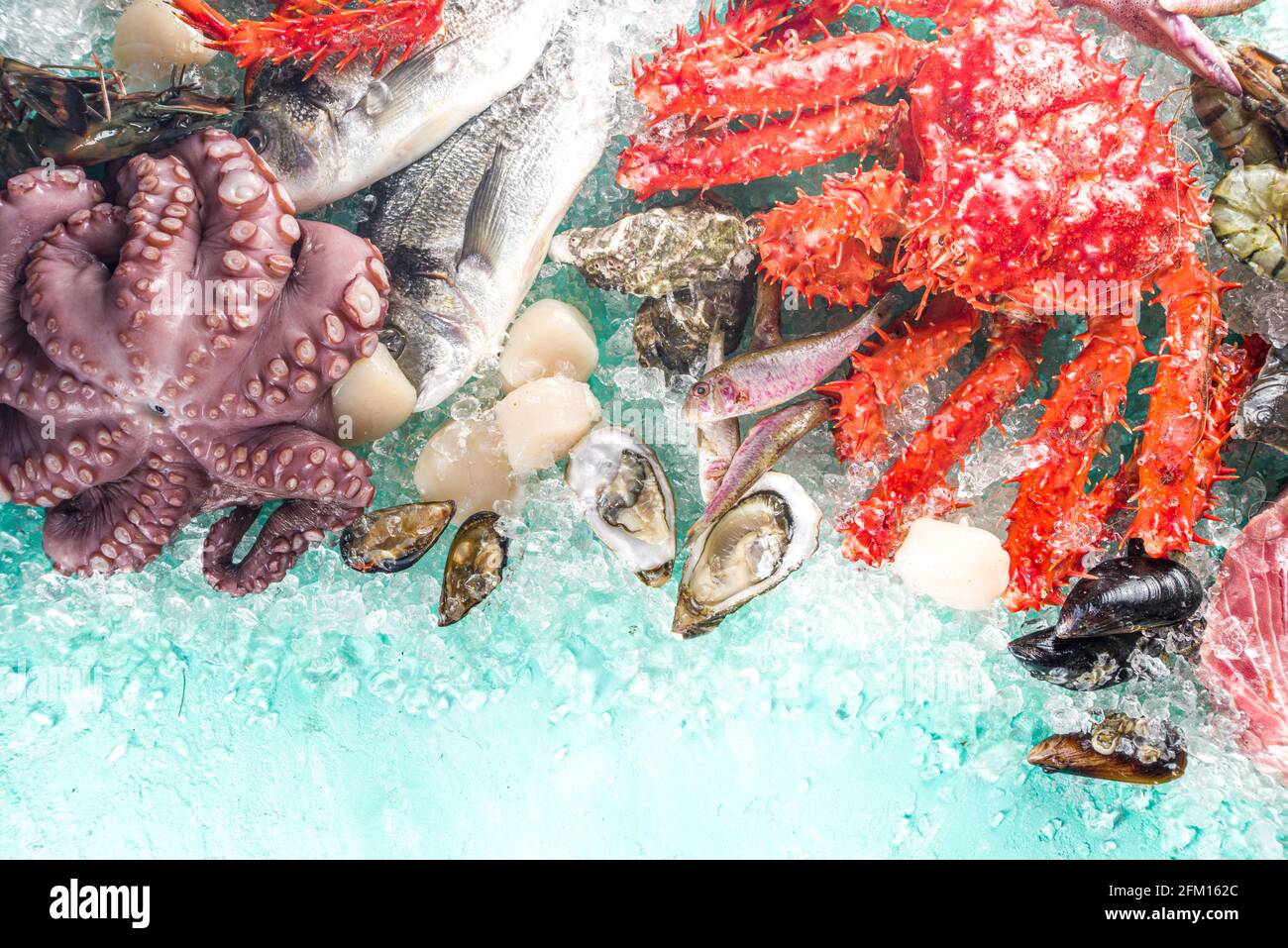 Ensemble de divers fruits de mer frais crus - pieuvre, crabe, calmar, crevettes, huître, moules, saumon thon dorada poisson avec épices d'herbes citron, bleu clair Banque D'Images
