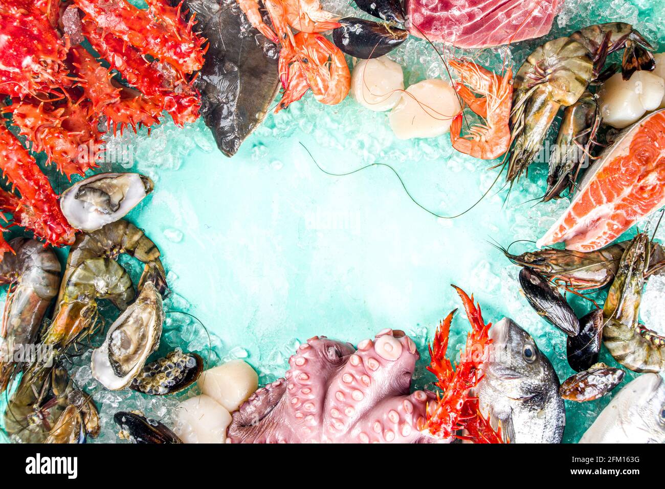 Ensemble de divers fruits de mer frais crus - pieuvre, crabe, calmar, crevettes, huître, moules, saumon thon dorada poisson avec épices d'herbes citron, bleu clair Banque D'Images