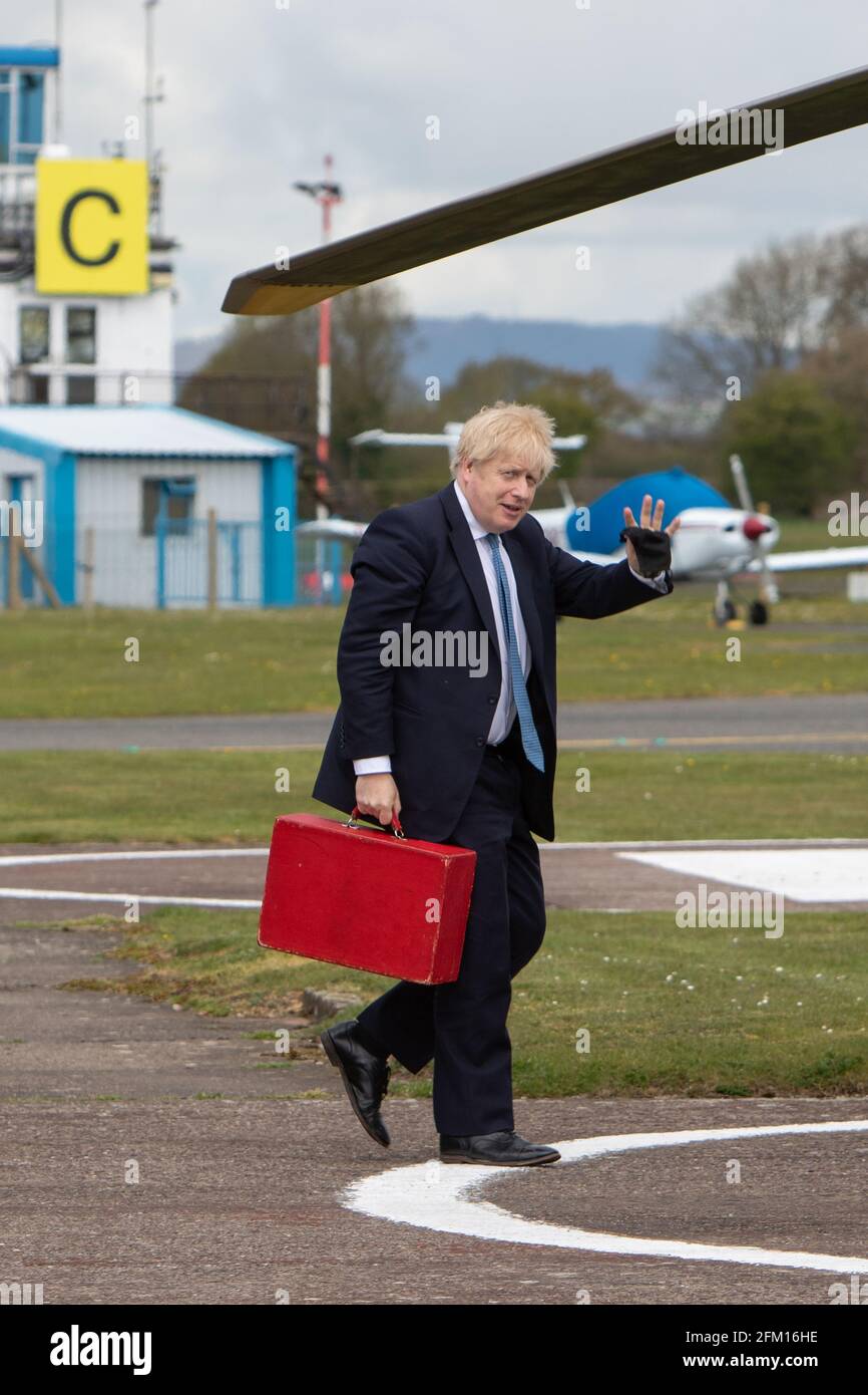 Aéroport de Wolverhampton Halfpenny Green, Royaume-Uni, 5 mai 2021. Le Premier ministre Boris Johnson se fait une vague devant les pillards alors qu'il monte à bord de son hélicoptère après une visite dans le pays noir, le dernier jour de campagne en vue des élections locales du jeudi en Angleterre. Le premier ministre est revenu de Stourbridge où il s'était joint plus tôt au maire de West Midlands, Andy Street, pour une promenade en vélo sur le canal et a aidé à distribuer des dépliants de campagne. Credit: Paul Bunch / Alamy Live News. Banque D'Images