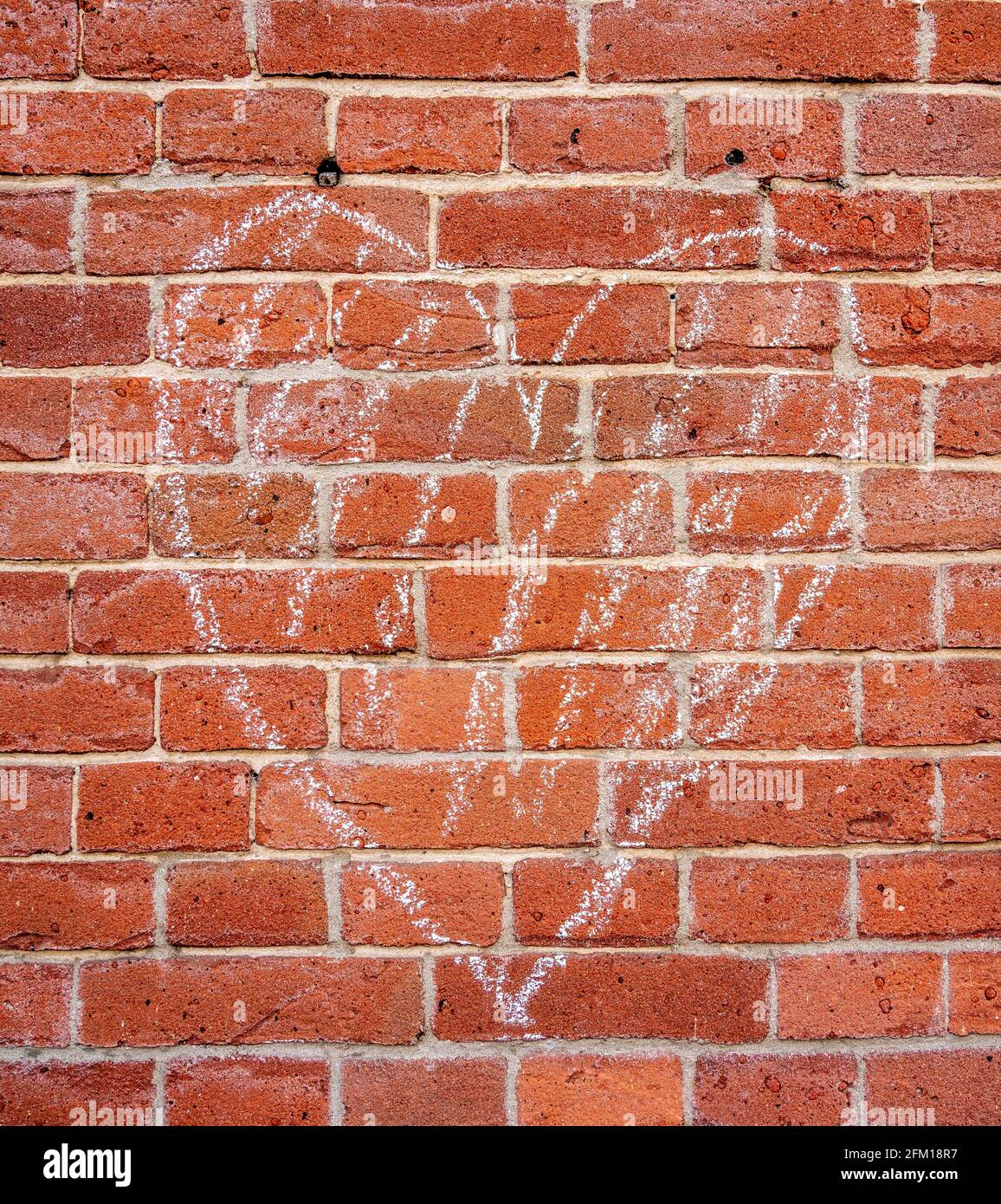 Arrière-plan d'un coeur de craie dessiné sur un mur de brique Banque D'Images
