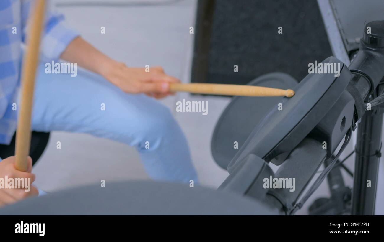 Femme jouant sur un ensemble de batterie électronique Banque D'Images