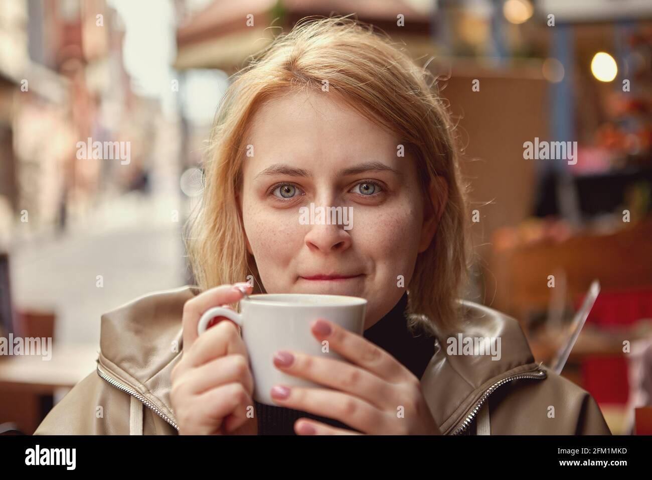 Une femme boit du café à table dans le café de rue à Istanbul. Banque D'Images