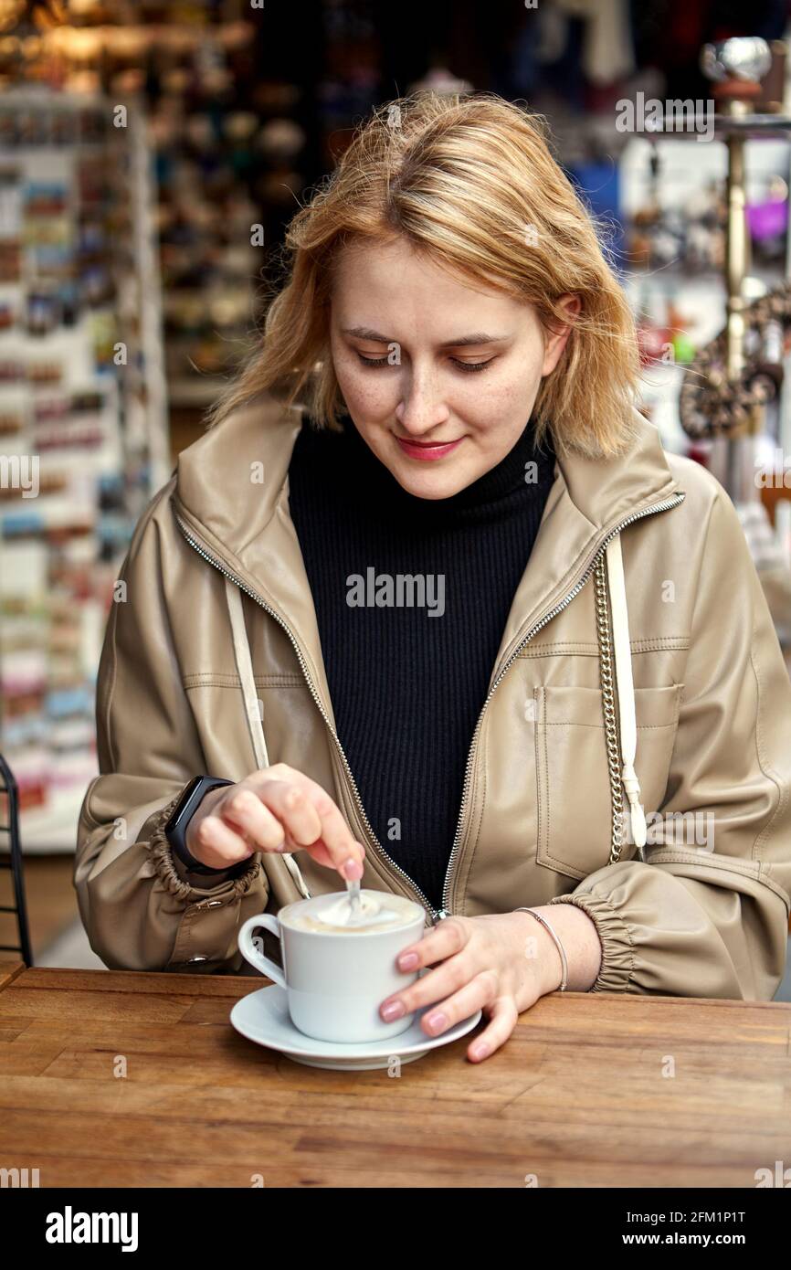 Street café à Istanbul, une jeune femme européenne boit du café à table. Banque D'Images