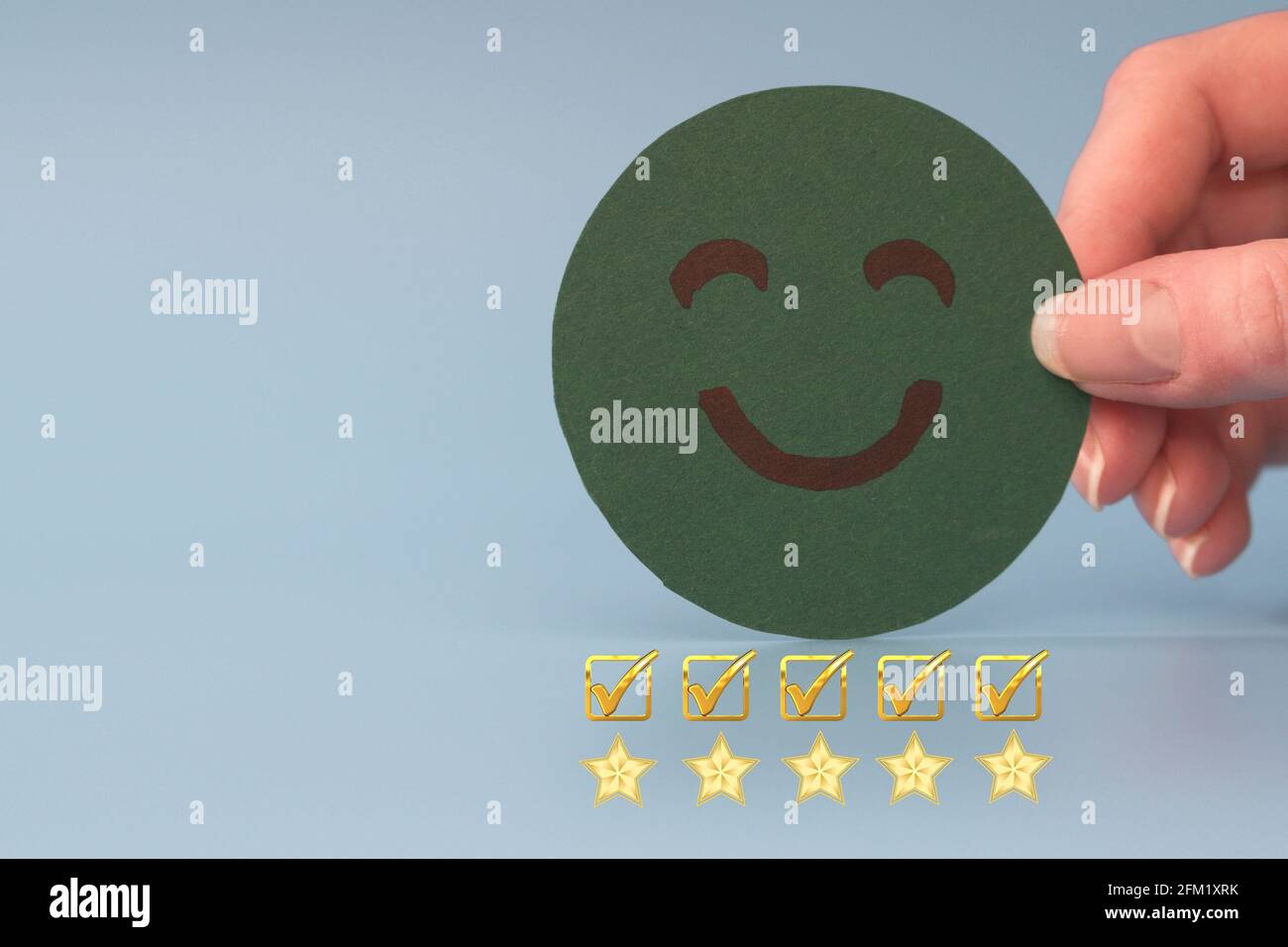 Concept d'enquête sur l'expérience et la satisfaction du service client. La main du client a choisi le visage souriant du visage heureux. Cinq étoiles excellent classement sur fond bleu Banque D'Images