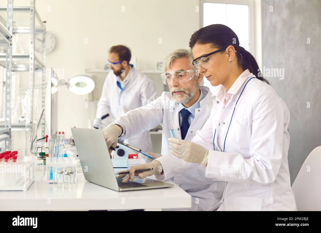 Ancien professeur et jeune scientifique travaillant en laboratoire discutant des tests résultat Banque D'Images