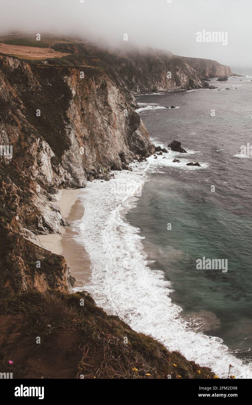 Photo panoramique de la magnifique côte de Big sur de Californie par un jour brumeux, Etats-Unis d'Amérique alias Etats-Unis. Vagues mousseuse dans l'océan et la montagne rocheuse Banque D'Images