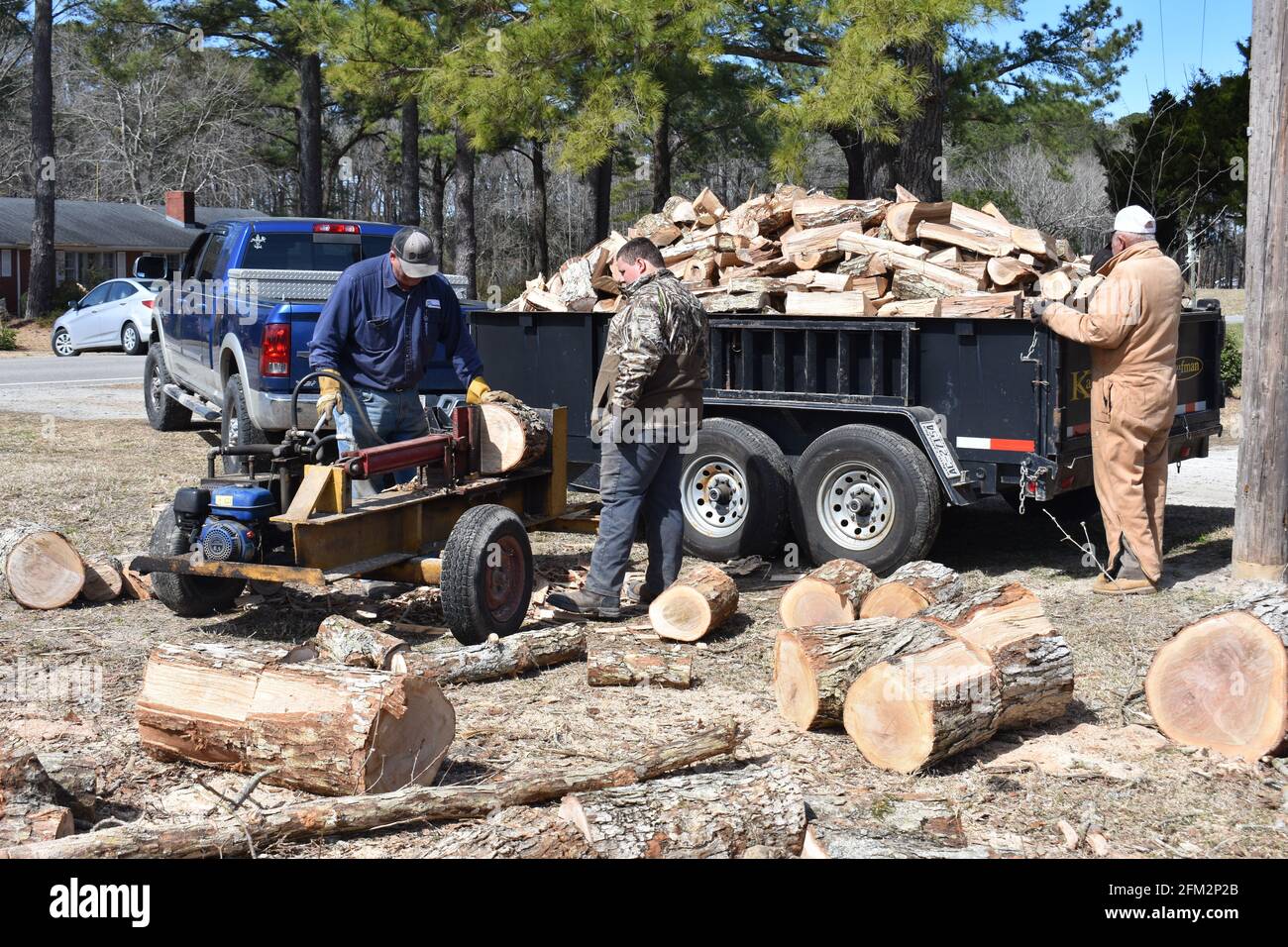 Les hommes fendant des bûches pour produire du bois de chauffage. Banque D'Images