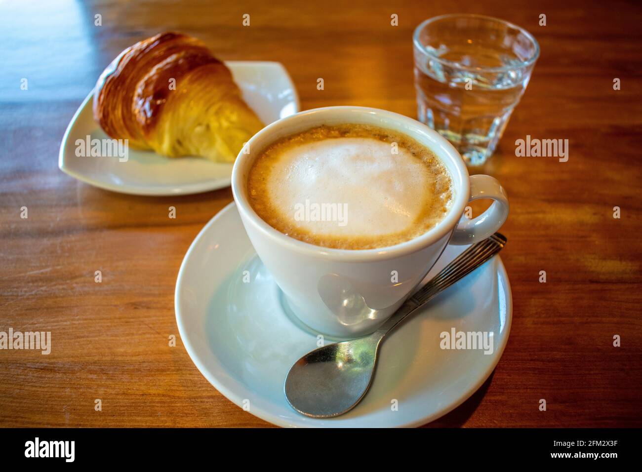 Café avec lait (latte) et croissant au beurre. Banque D'Images