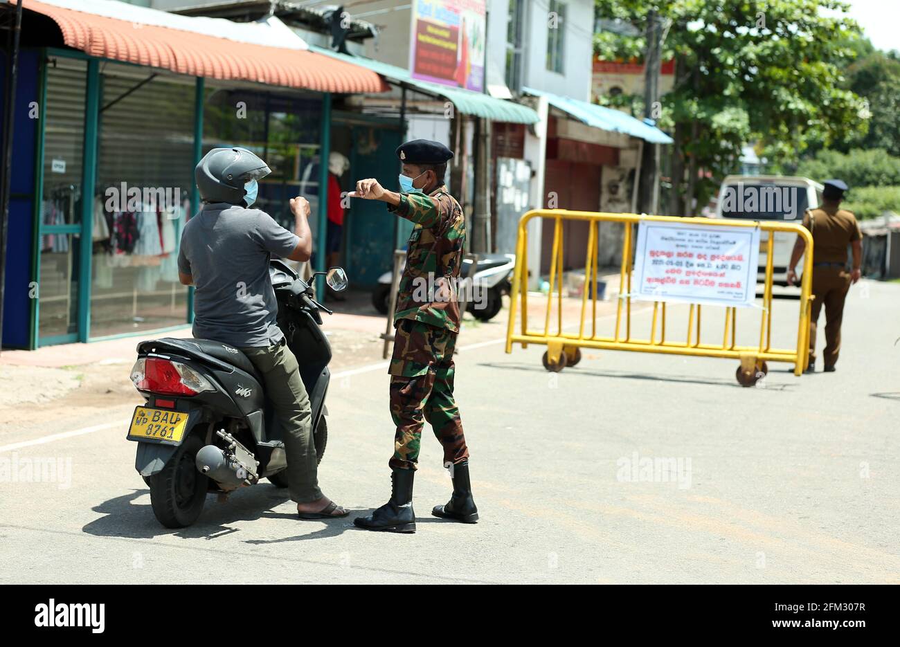 Colombo, Sri Lanka. 5 mai 2021. Un membre de l'armée parle à un homme à côté de barricades établies à Maharagama, alors que les autorités sanitaires ont déclaré la zone à isoler, à Colombo, au Sri Lanka, le 5 mai 2021. Le nombre total de patients infectés par le COVID-19 au Sri Lanka a dépassé la barre des 115,000 mercredi après que plus de 1,800 nouveaux patients ont été identifiés un jour plus tôt, ont montré les statistiques du ministère de la Santé. Crédit: Ajith Perera/Xinhua/Alamy Live News Banque D'Images