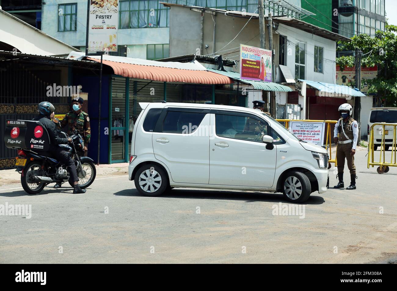 Colombo, Sri Lanka. 5 mai 2021. Des membres de l'armée et de la police sont vus à côté de barricades établies à Maharagama, alors que les autorités sanitaires ont déclaré la zone à isoler, à Colombo, au Sri Lanka, le 5 mai 2021. Le nombre total de patients infectés par le COVID-19 au Sri Lanka a dépassé la barre des 115,000 mercredi après que plus de 1,800 nouveaux patients ont été identifiés un jour plus tôt, ont montré les statistiques du ministère de la Santé. Crédit: Ajith Perera/Xinhua/Alamy Live News Banque D'Images