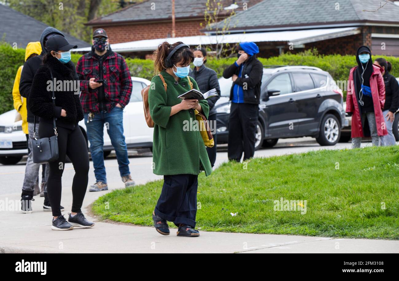 Toronto, Canada. 5 mai 2021. Les personnes portant un masque facial s'alignent pour entrer dans une clinique de vaccination COVID-19 à Toronto, Ontario, Canada, le 5 mai 2021. L'Ontario, la province la plus peuplée du Canada, a signalé 2,941 nouveaux cas de COVID-19 mercredi matin, portant le total cumulatif du pays à 1,252,891 cas, selon CTV. Credit: Zou Zheng/Xinhua/Alamy Live News Banque D'Images