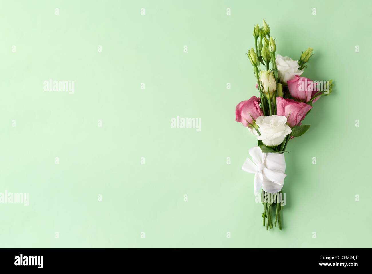 Bouquet de fleurs eustoma rose et blanc sur fond vert isolé Banque D'Images