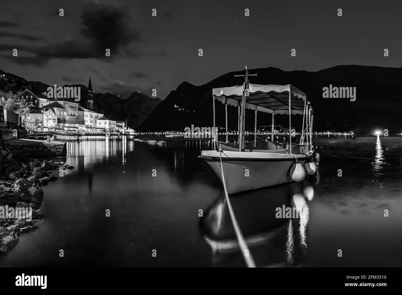 Une exposition longue, Teal et orange sunset panorama de la baie de Kotor et un bateau amarré dans la parfaite carte postale ville de Perast Montenegro, montagnes en arrière-plan Banque D'Images