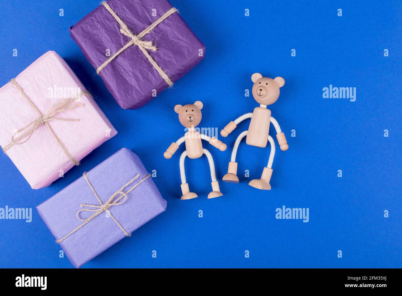 Arrière-plan de la fête des pères. Carte de vœux avec une famille de jouets en bois d'ours en peluche et boîte cadeau sur fond bleu. Pose à plat. Copier l'espace. Banque D'Images