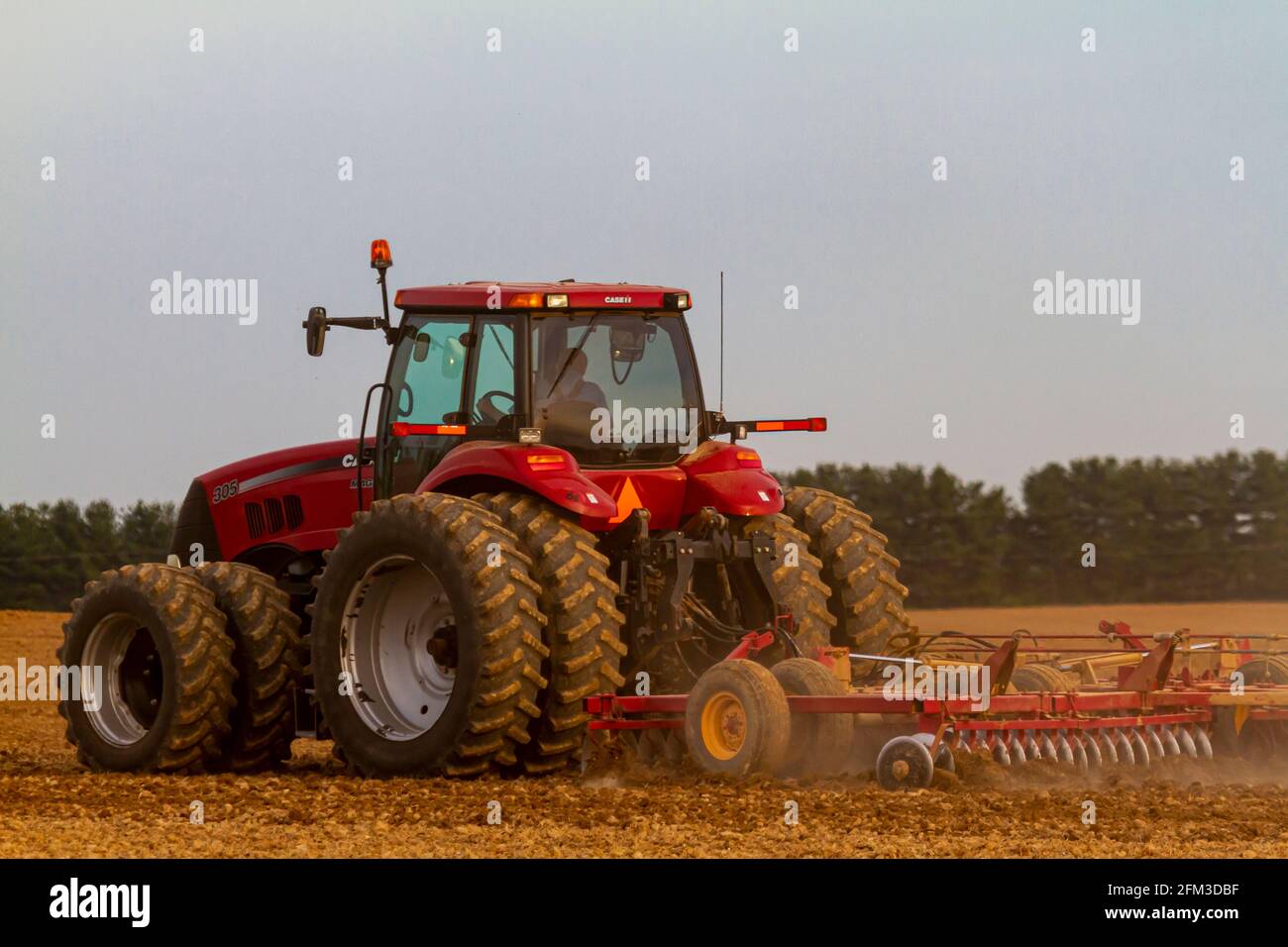 Chestertown, MD, États-Unis 05-02-2021: Le tracteur Red six Wheel case IH Magnum 305 avec cabine laboure un champ agricole vierge au printemps. La charrue a Banque D'Images