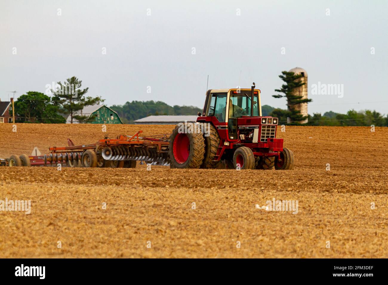 Chestertown, MD, États-Unis 05-02-2021: Un tracteur international 1586 à six roues rouge avec cabine laboure un champ agricole vierge au printemps. Il y en a Banque D'Images