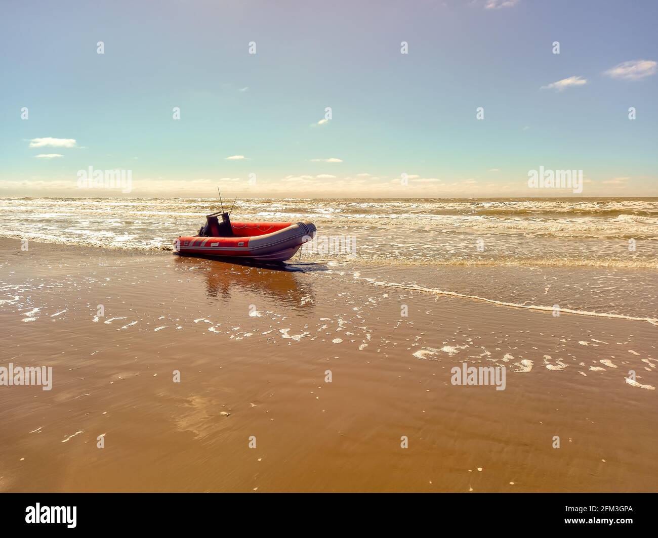 Bateau gonflable à coque rigide avec moteur hors-bord sur la rive battue par les vagues. Utilisé pour pêcher en mer Banque D'Images