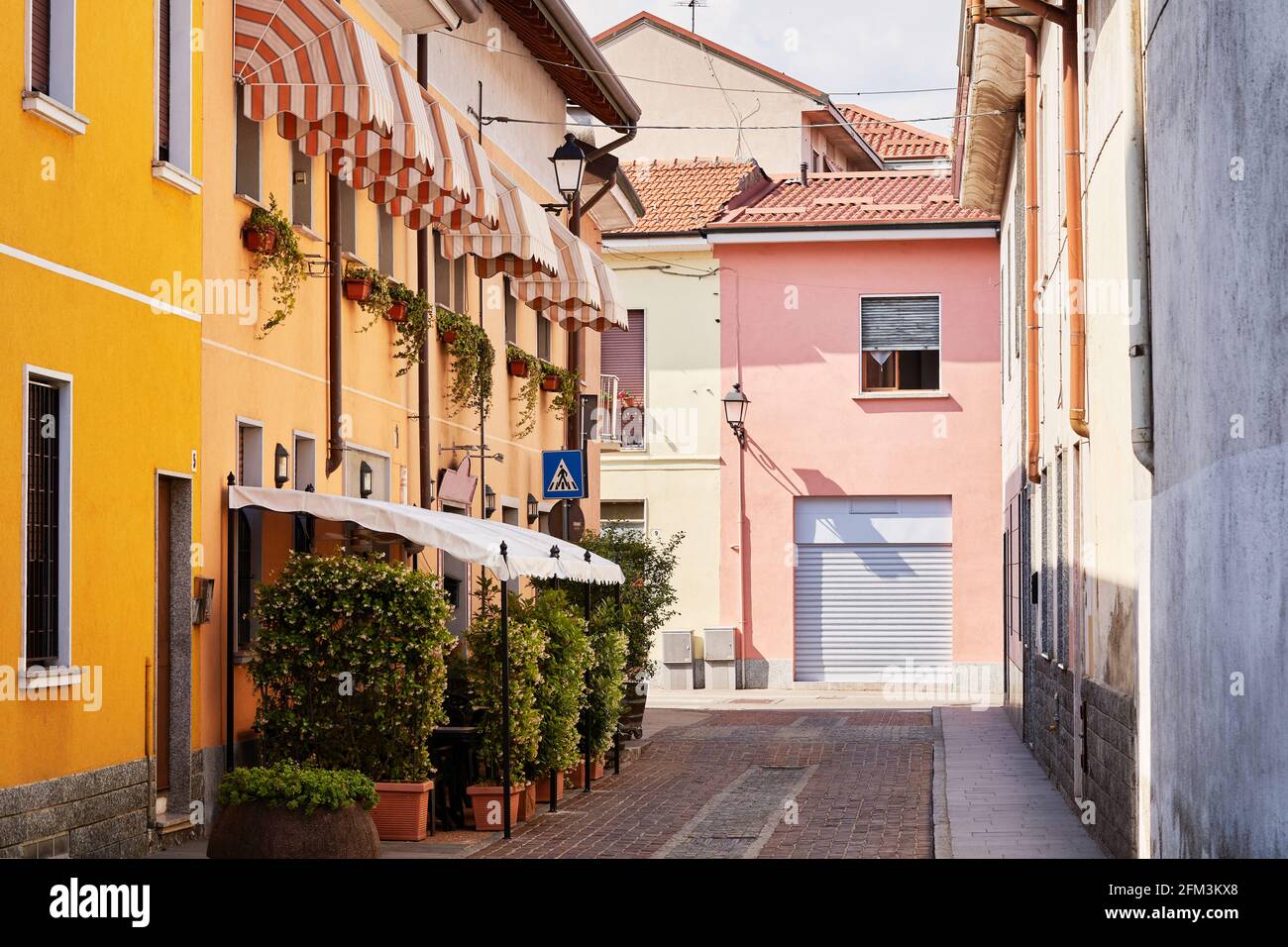 Terrasse de restaurant en plein air sur une petite rue italienne intime, café dans la petite ville de Lombardie, Italie. Extérieur de la Trattoria Banque D'Images