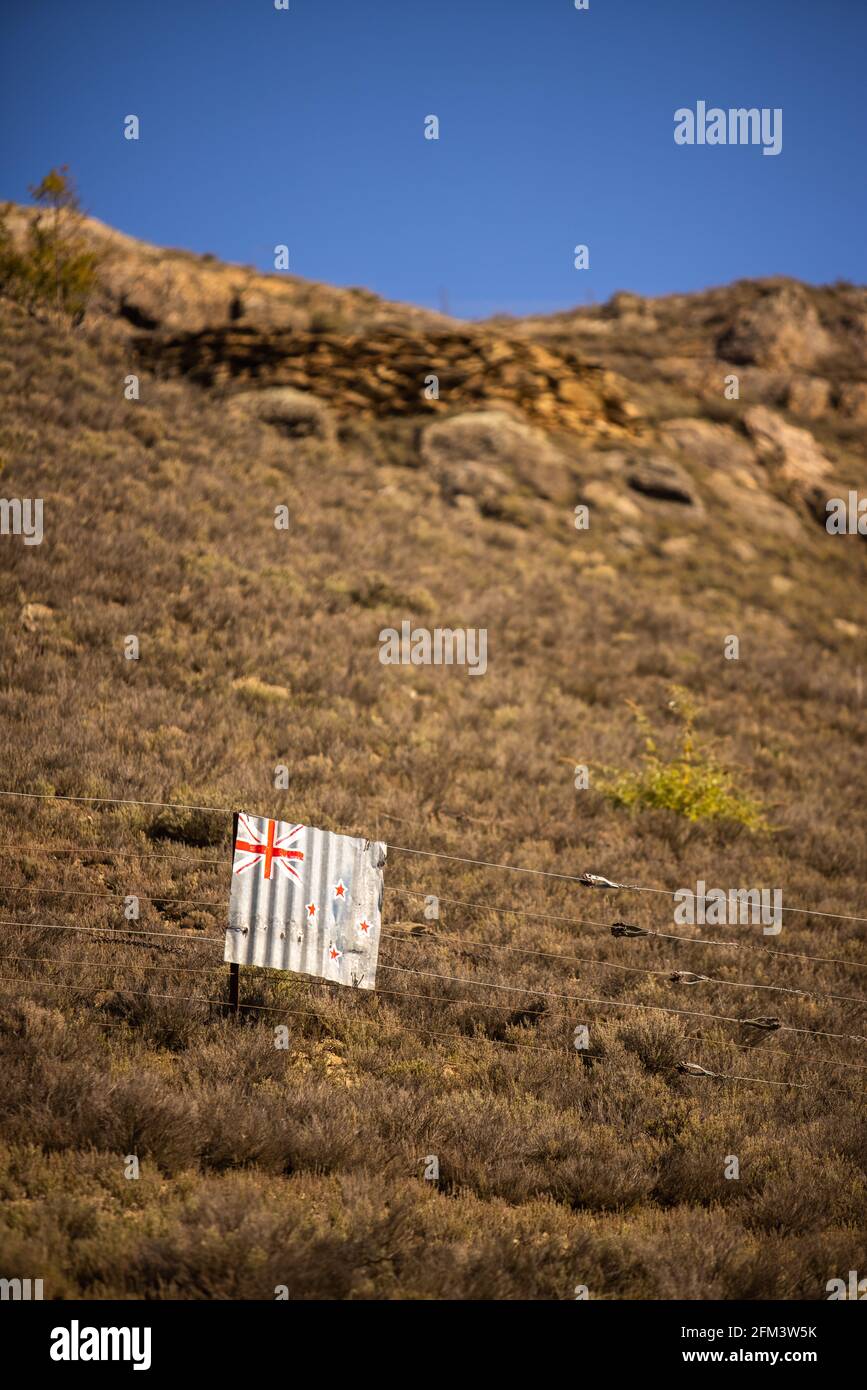 Drapeau de Nouvelle-Zélande peint sur fer ondulé suspendu sur un fil de clôture ion a Hillside, Central Otago, South Island, Nouvelle-Zélande Banque D'Images