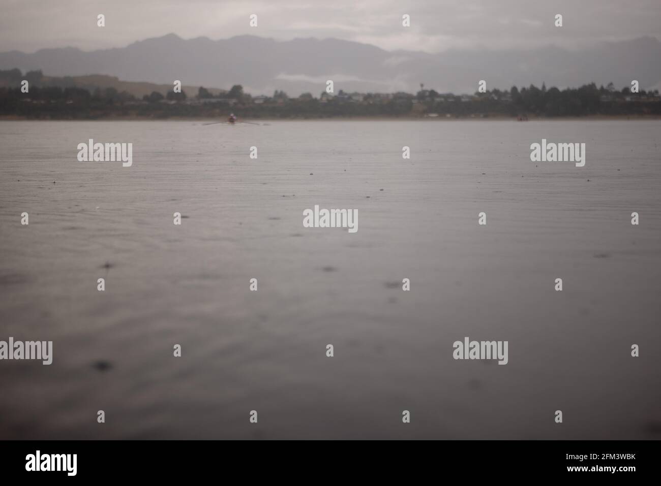 Rameurs sur un lac tacheté de pluie, Manapouri, Île du Sud, Nouvelle-Zélande Banque D'Images