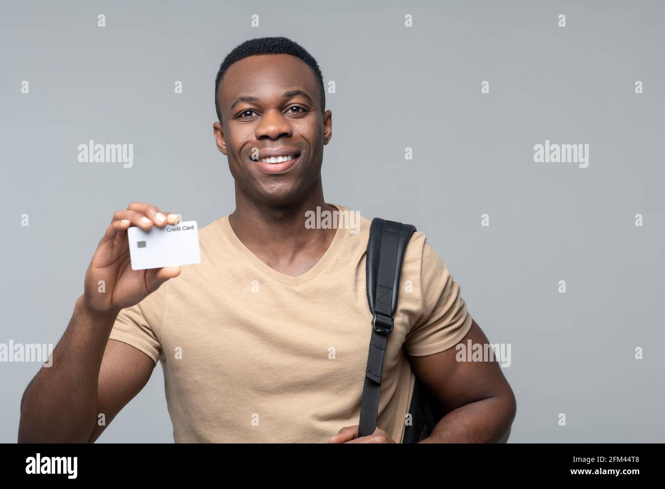 Joyeux sourire afro-américain montrant la carte de crédit Banque D'Images