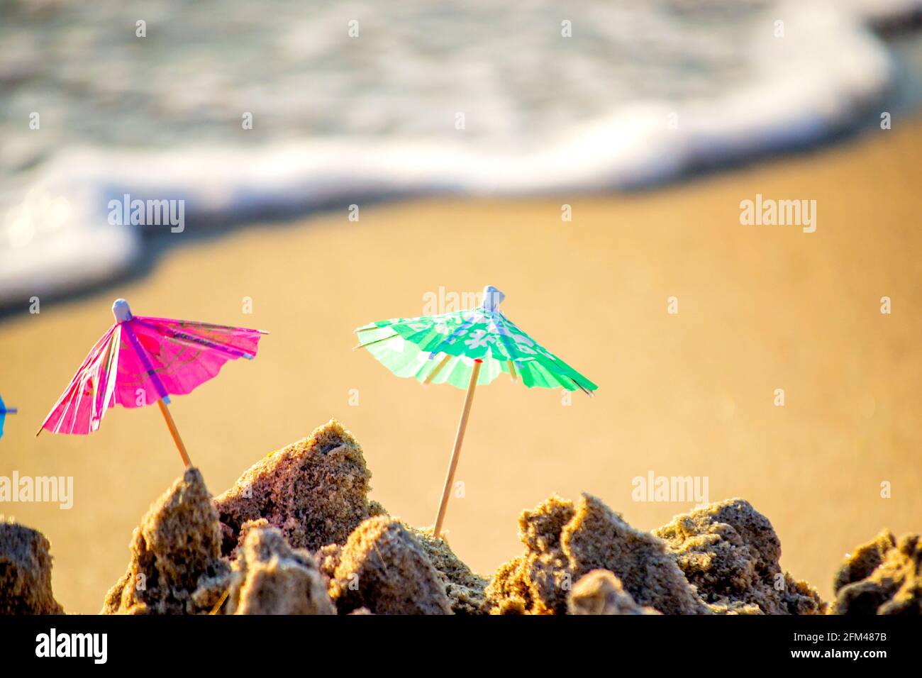 Petits parasols de plage en papier pour les cocktails sable Banque D'Images