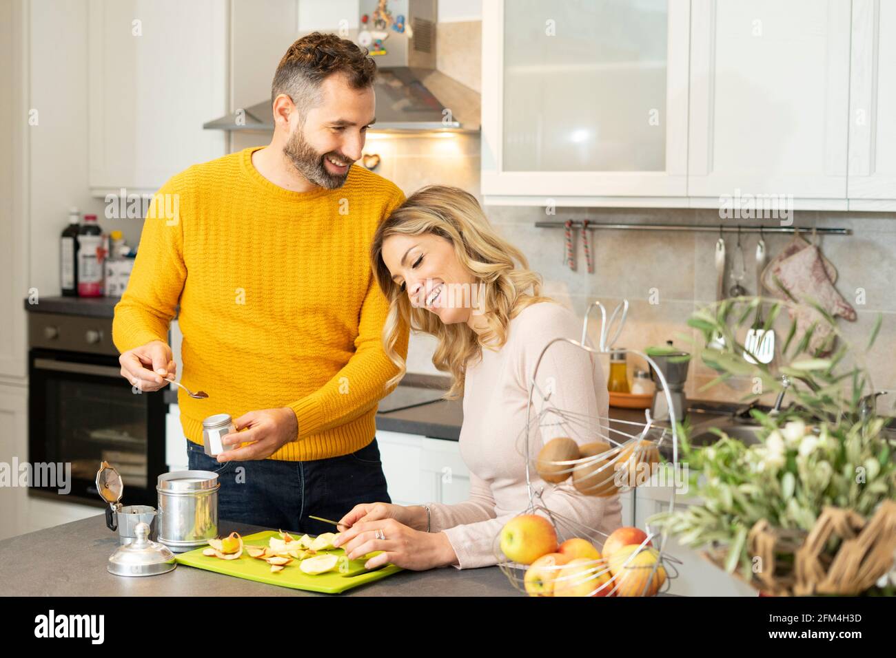 Bon couple dans la cuisine. Un jeune couple romantique prépare des fruits frais et du café. Vie saine et amour. Souriant, les gens vivent ensemble. Banque D'Images