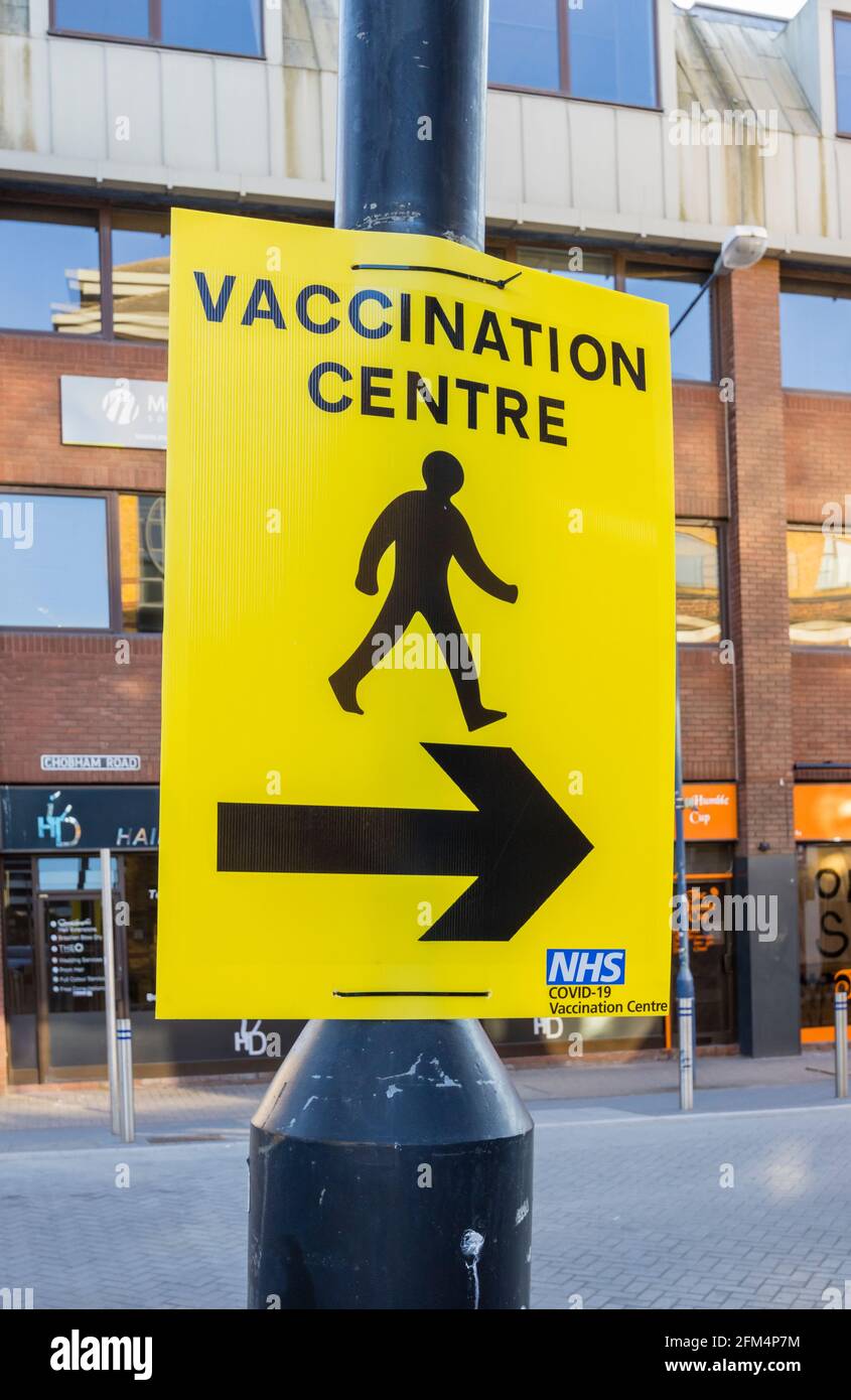 Panneau jaune NHS indiquant le centre de vaccination COVID-19 dans le centre-ville de Woking, Surrey, Angleterre Banque D'Images