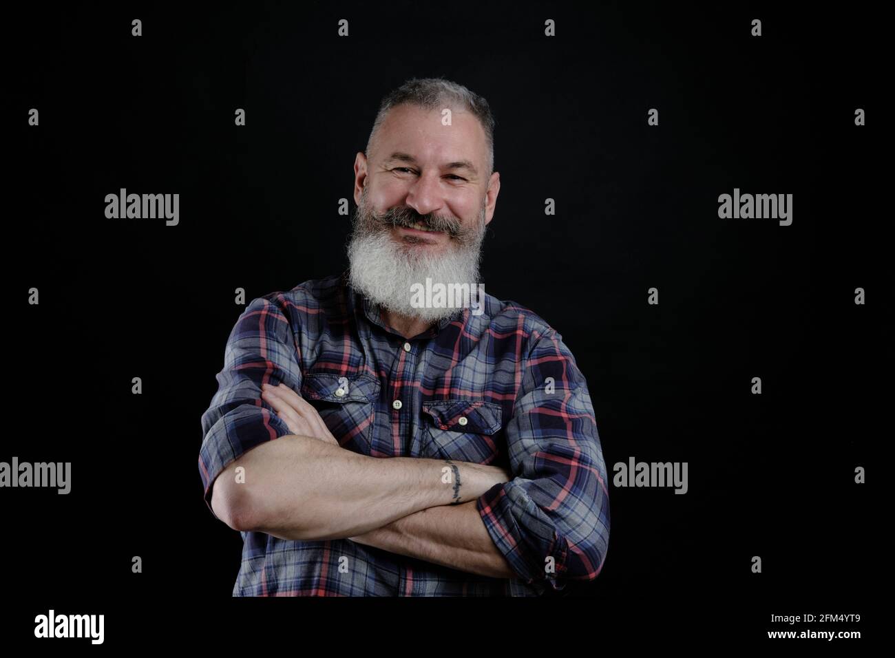 Portrait d'un beau homme mature barbu isolé sur fond noir, homme caucasien avec la barbe souriante Banque D'Images