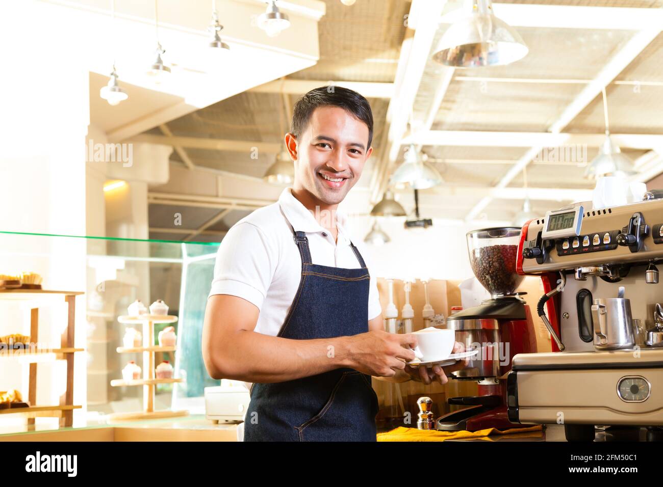 Coffeeshop - café barista asiatique présente dans son magasin Banque D'Images