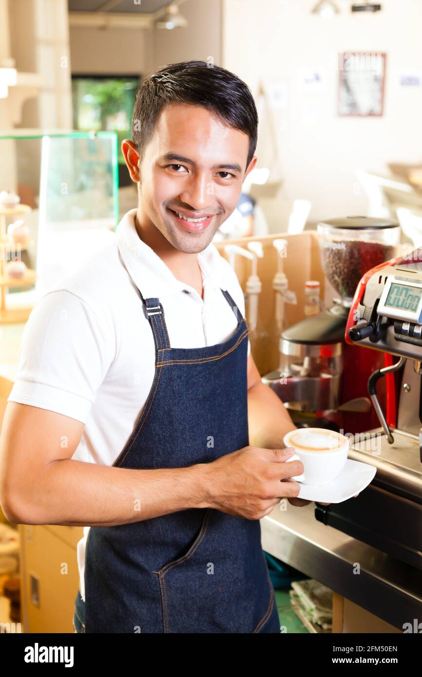 Coffeeshop - café barista asiatique présente dans son magasin Banque D'Images