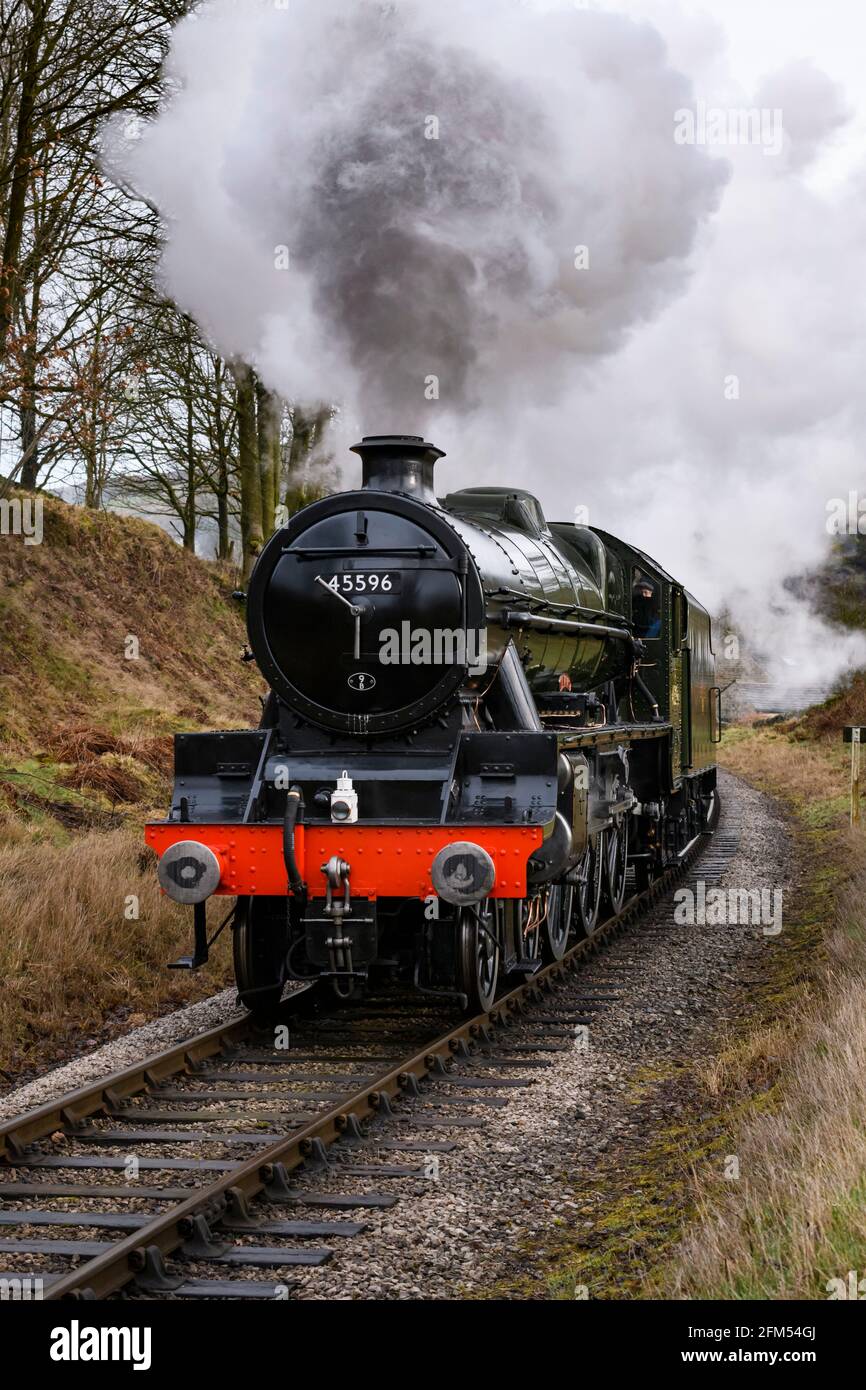 Train à vapeur historique (Loco) en train de se déplacer dans la voie, en train de fumée de bourrer des nuages voyageant sur le pittoresque chemin de fer rural du patrimoine - KWVR, Yorkshire Angleterre Royaume-Uni. Banque D'Images