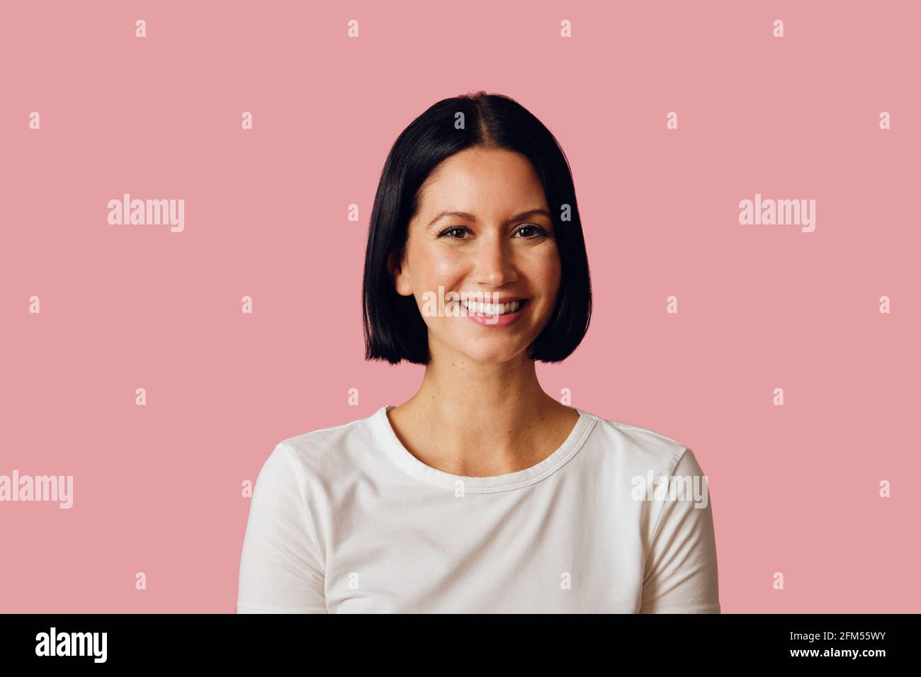 Gros plan portrait studio de brunette heureux souriant regardant l'appareil photo Banque D'Images