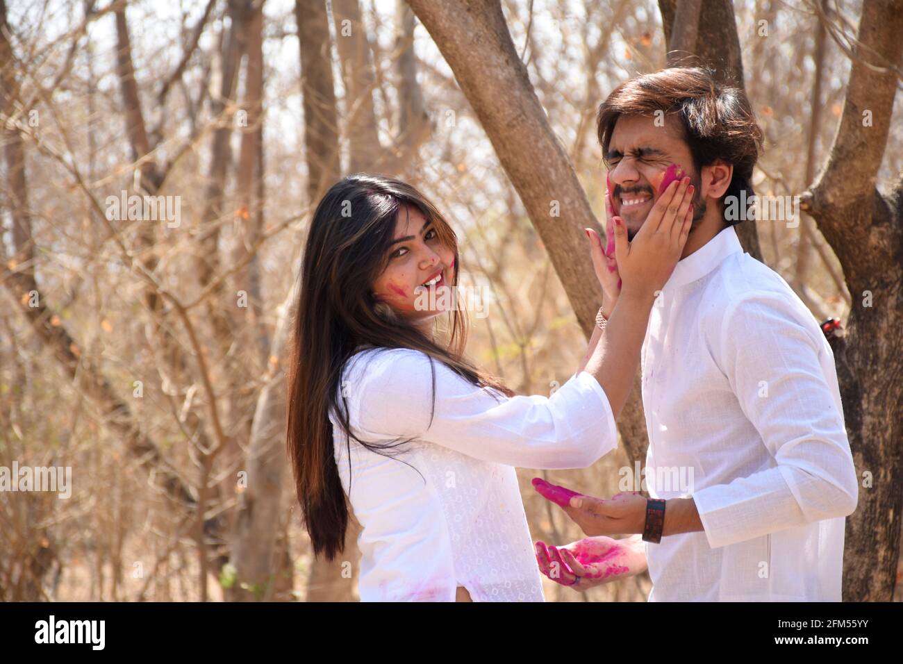 Jeune homme et femme célébrant le festival Holi avec de la poudre colorée sur la face Banque D'Images