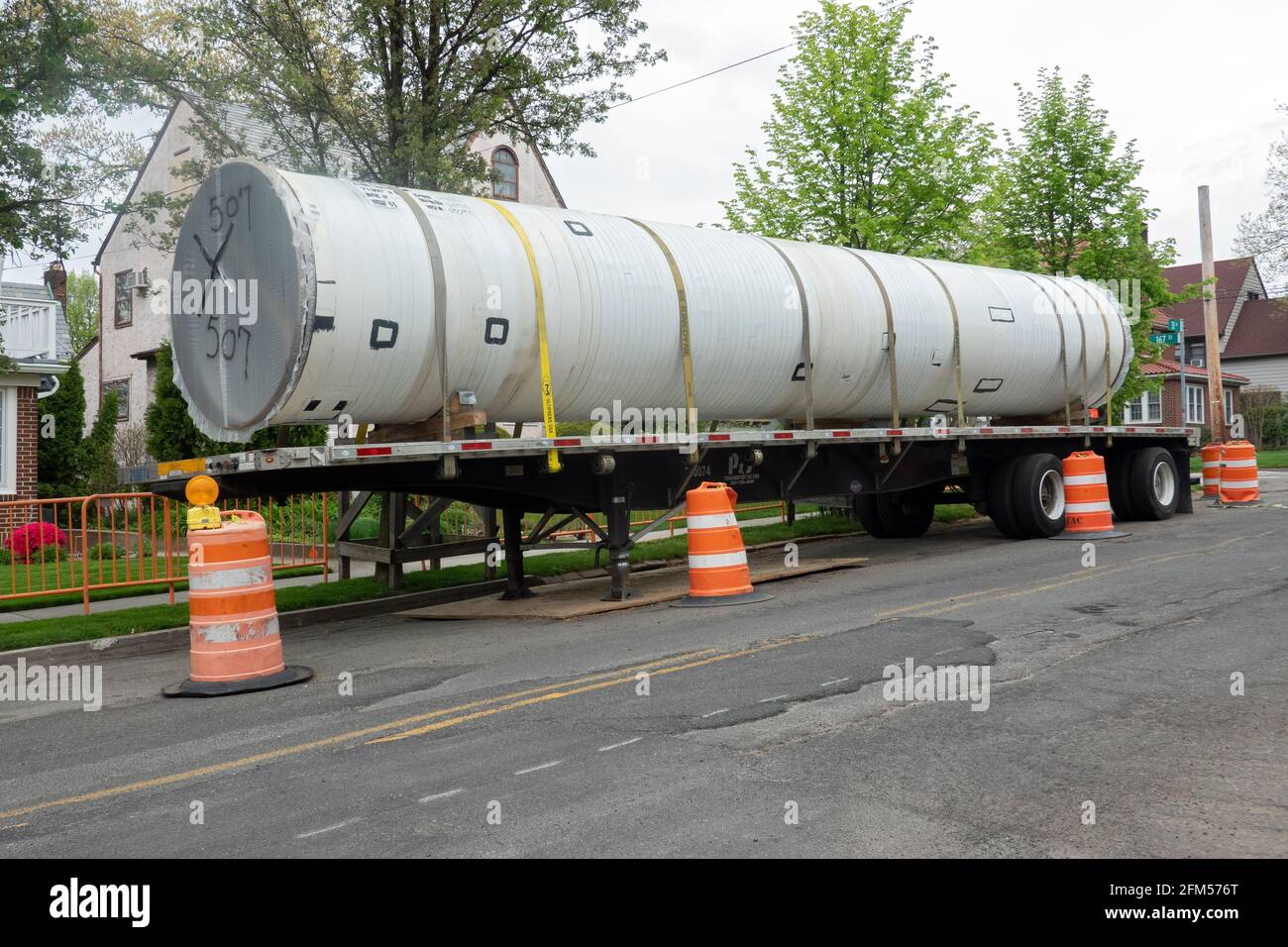 Un tuyau d'égout de remplacement sur un camion à plateau sur le point d'être installé dans un quartier résidentiel de Northwest Queens, à New York. Banque D'Images