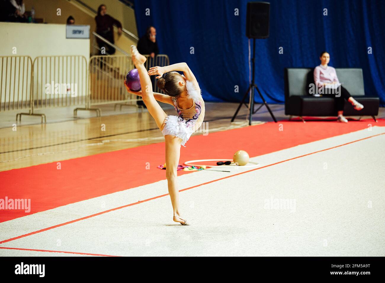 une fillette de gymnaste se produit avec un cerceau. un athlète flexible se produit sur une stand lors des compétitions Banque D'Images