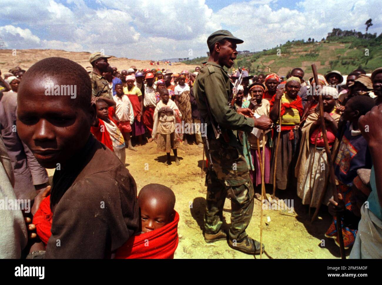 Les gens qui ont été installés de force le 1999 février dans le cadre du programme de villageois « controversé », faisant la queue pour des couvertures de savon et des jerricans au camp de Mucaca après avoir marché depuis leurs villages périphériques. Le camp était un camp de personnes déplacées et abritait jusqu'à récemment 45,000 personnes. Il est maintenant utilisé comme centre de distribution pour l'aide. Il est situé dans la commune de Cyeru, province de Ruhengeri, Nord-Ouest du Rwanda. 14.2.1999 Photo : JOHN VOOS Banque D'Images