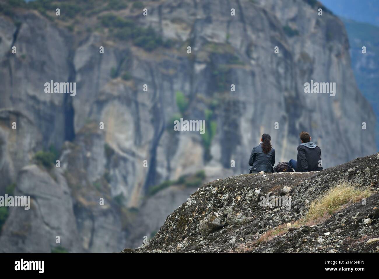 Jeune couple surplombant les formations rocheuses de grès créées pendant la période du Paléogène à Meteora, Kalambaka Thessalie, Grèce. Banque D'Images