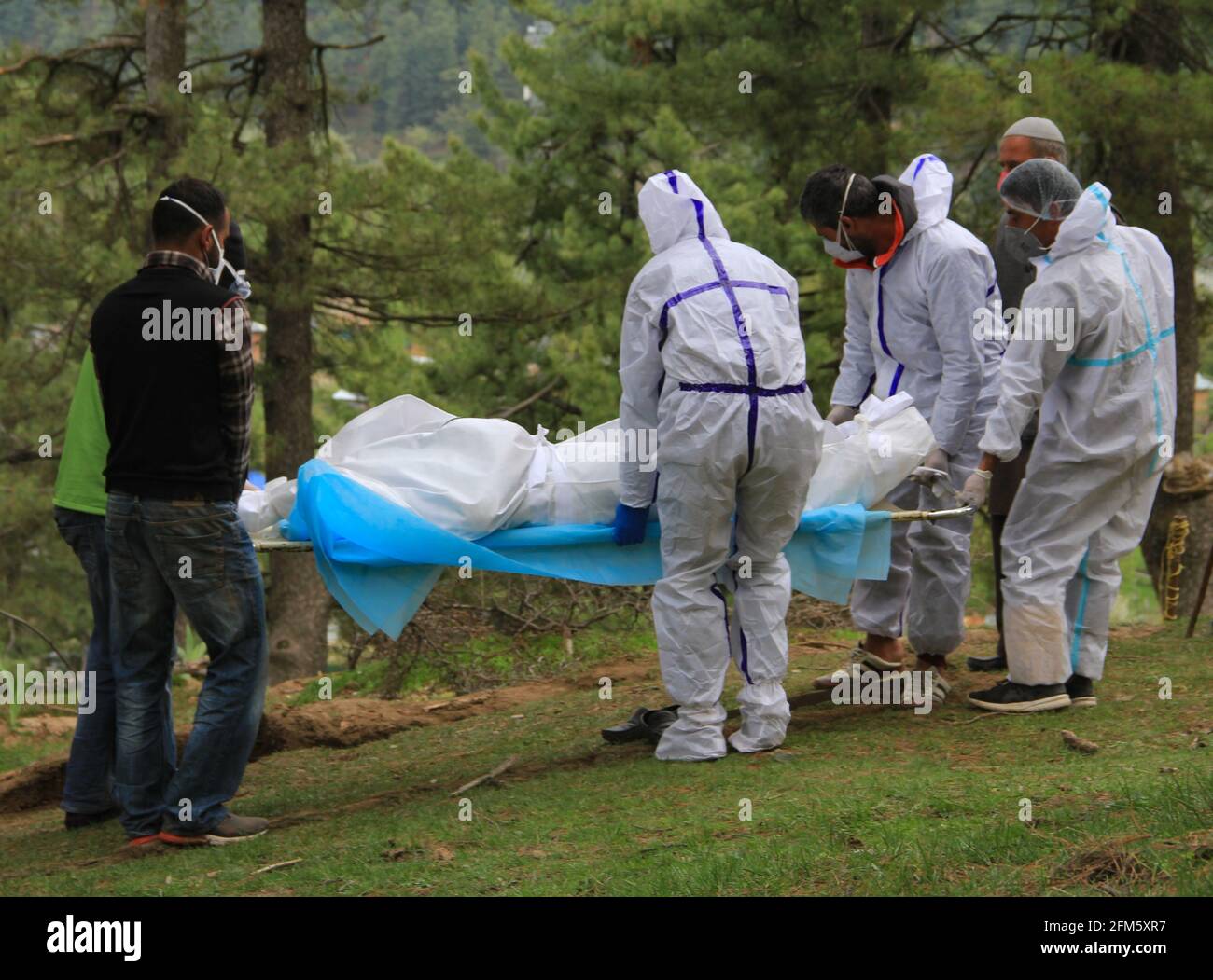 6 mai 2021, SRINAGAR, JAMMU ANDKASHMIR, INDE: Parents les professionnels de la santé portant des combinaisons protectrices portent le corps mort de femmes musulmanes de 60 ans qui sont mortes du coronavirus COVID-19 pour inhumation, dans un cimetière de Tangmarg, à environ 44 kilomètres au nord de la ville de srinagar, le mois d'avril. 06,2021 (Credit image: © Sajad HameedZUMA Wire) Banque D'Images