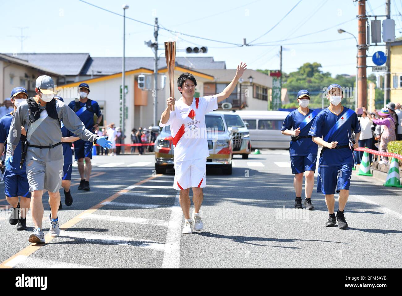 (210506) -- TOKYO, le 6 mai 2021 (Xinhua) -- l'ancien Olympien Eriguchi Masashi (C) court avec la torche pendant le relais de la torche olympique de Tokyo dans la préfecture de Kumamoto, au Japon, le 6 mai 2021. (Tokyo 2020/document via Xinhua) Banque D'Images