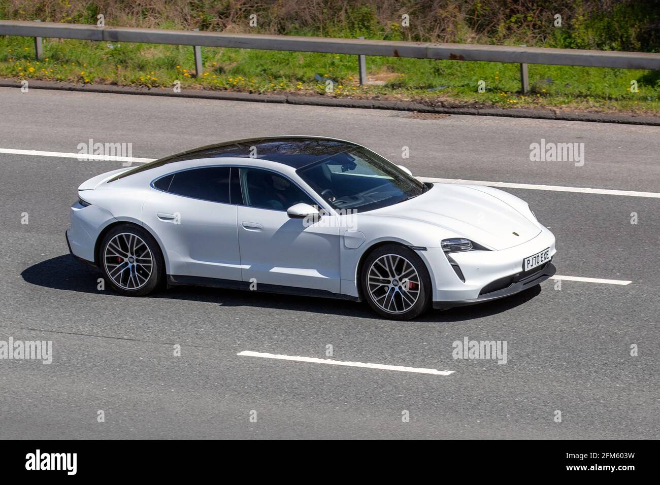 2020 blanc Porsche Taycan 45 93Kwh £88k performance EV, luxueuse voiture de sport à quatre places; circulation automobile électrique, véhicules en mouvement, voitures, conduite de véhicules sur les routes britanniques, moteurs, conduite sur l'autoroute M6 réseau routier britannique. Banque D'Images