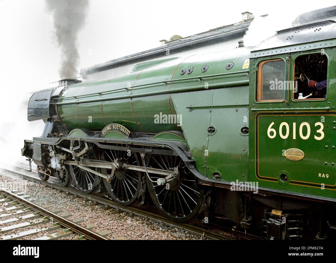 La main du conducteur est sur le régulateur, car la locomotive à vapeur Flying Scotsman laisse Salisbury dans la pluie battante.21.05.2016. Banque D'Images