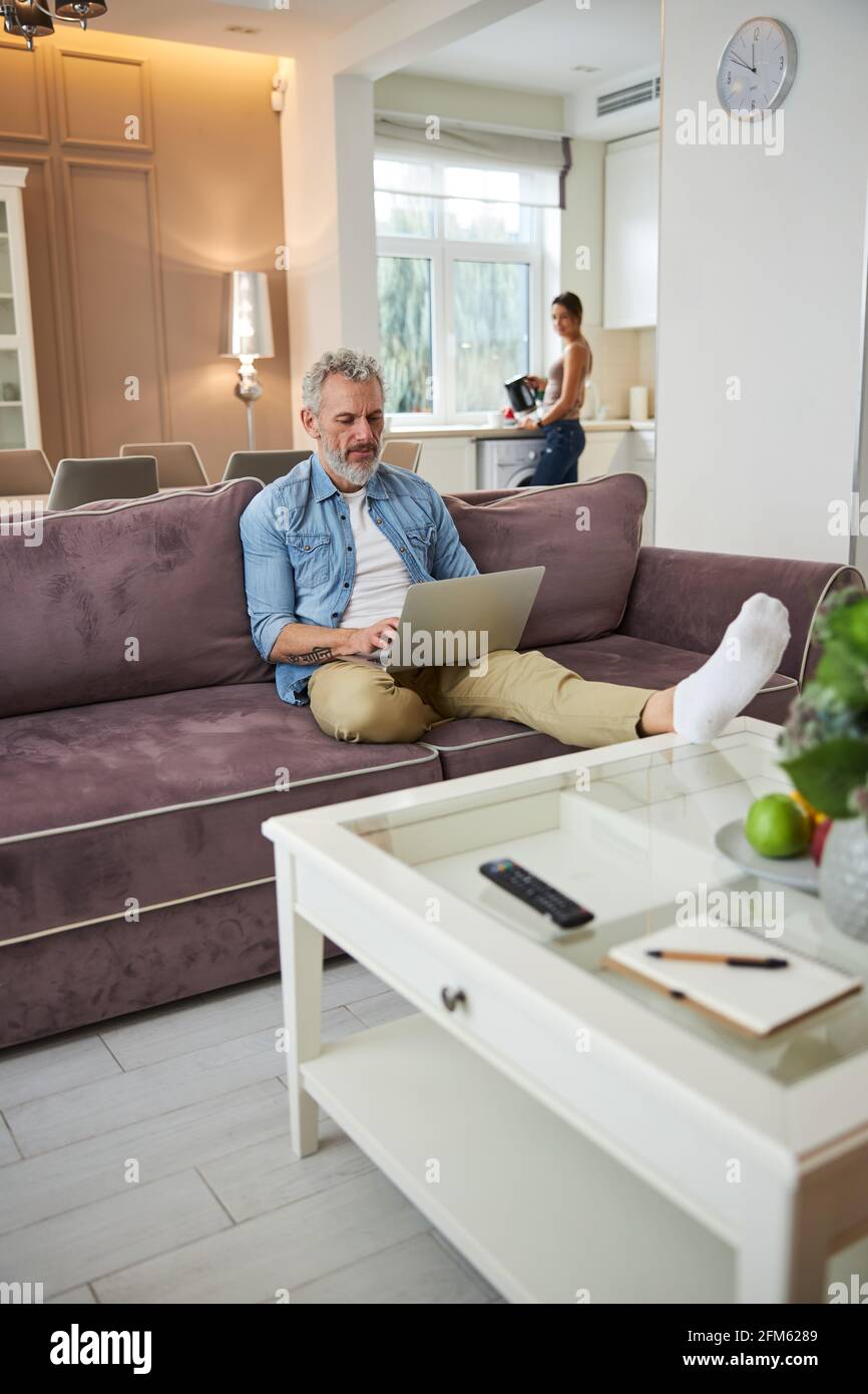 Homme barbu concentré en tapant la réponse sur le message Banque D'Images