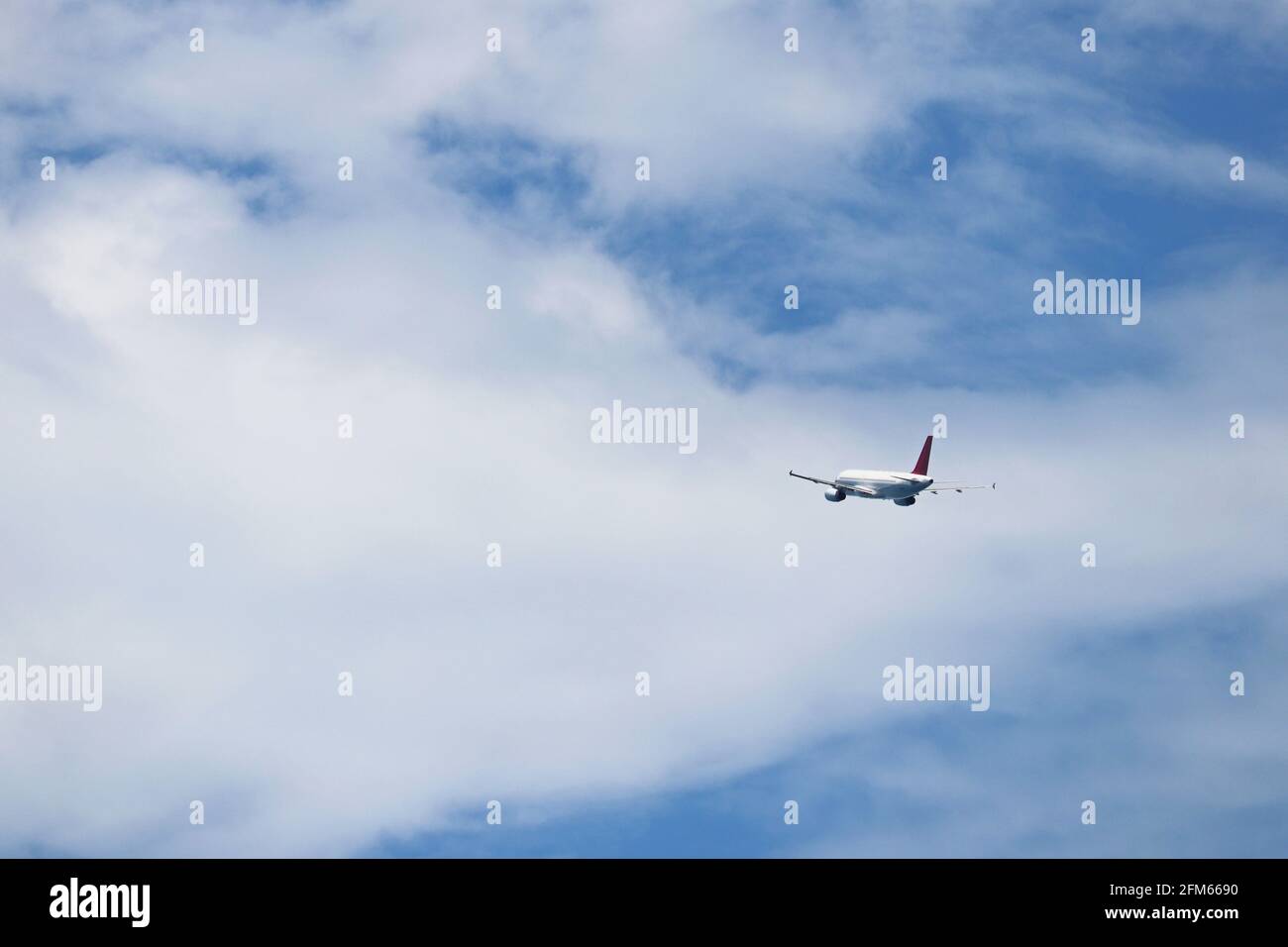 Avion volant dans le ciel bleu sur fond de nuages blancs, vue arrière. Avion commercial à deux moteurs pendant le tour, la turbulence et le concept de voyage Banque D'Images
