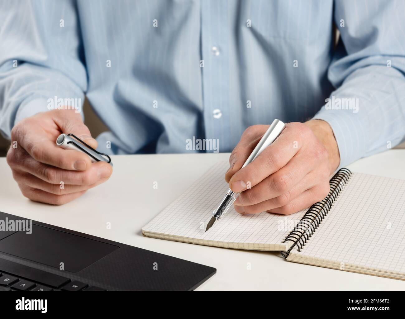 Homme à l'ordinateur avec un stylo à encre. Banque D'Images