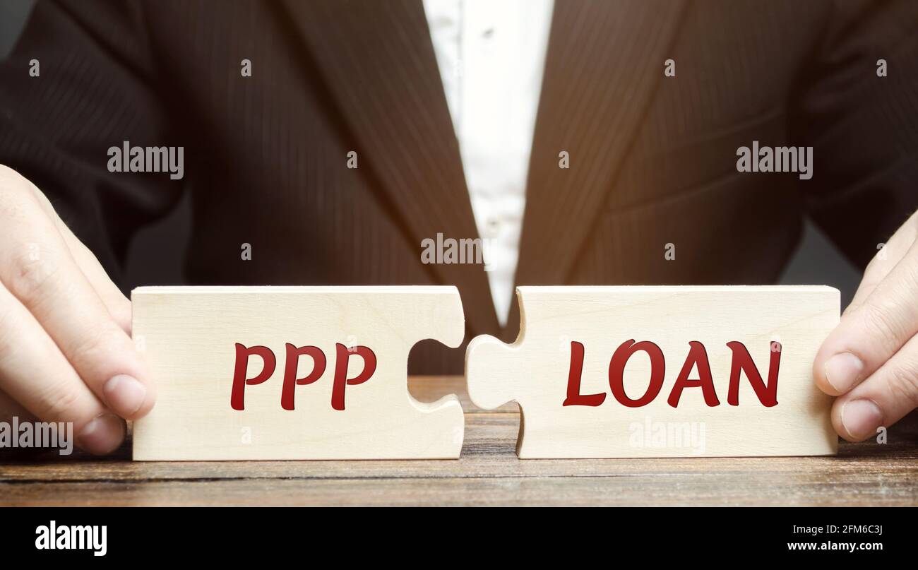 Homme d'affaires met des puzzles avec des mots PPP prêt - Paycheck protection Program. Prêt conçu pour fournir une incitation directe pour les petites entreprises de tenir t Banque D'Images