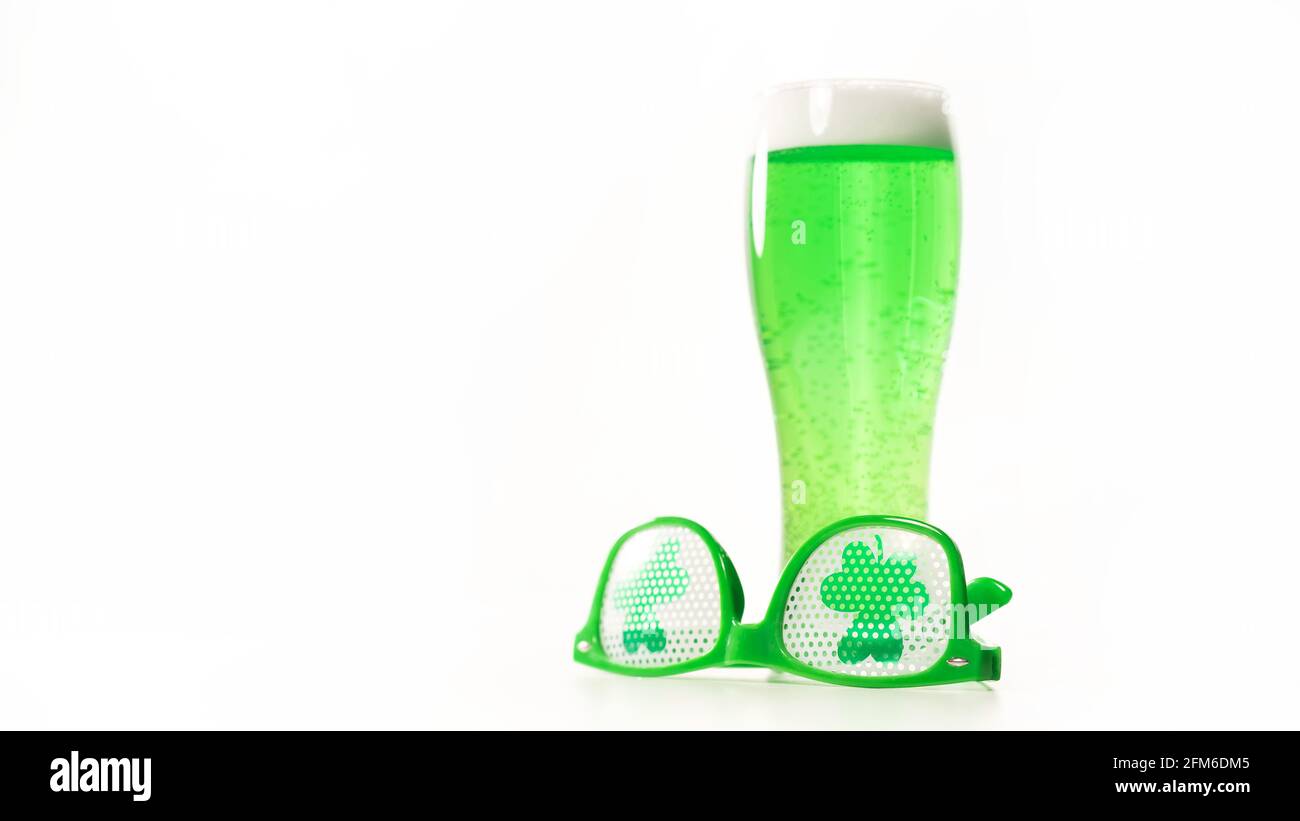 Un verre de bière verte et des verres drôles pour le jour de St patrick sur  fond blanc. Boisson irlandaise traditionnelle pour des vacances. Copier la  flèche Photo Stock - Alamy