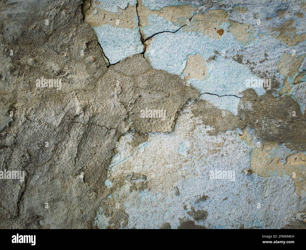 Mur en béton abîmé et fissuré maintenu au fil du temps avec de la chaux bleue et différents mélanges de mortier. Plâtre de décollement de la surface de la structure de ciment. Banque D'Images