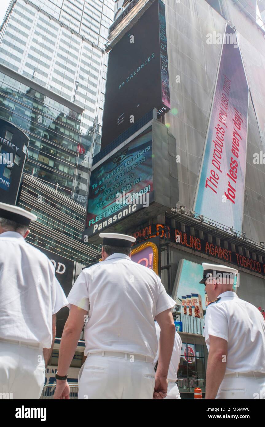 Trois hommes de la marine traversent Times Square à New York Banque D'Images Trois hommes de la marine traversent Times Square à New York Banque D'Images